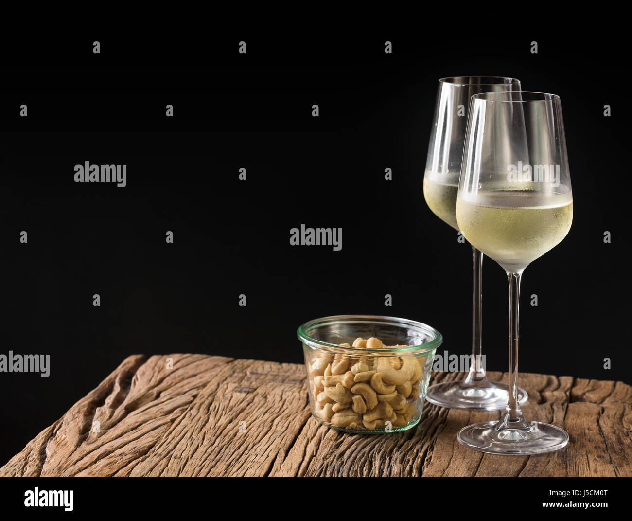 Due bicchieri di vino bianco su una tavola in legno rustico. Foto Stock