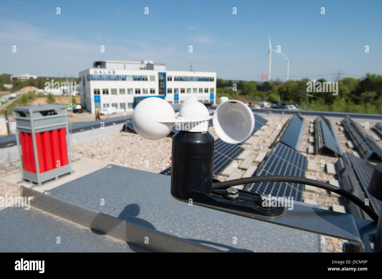 GERMANIA Amburgo, centro tecnologico HAW CC4E, energia intelligente, bombola di gas rossa per lo stoccaggio dell'idrogeno, l'idrogeno verde è stato trasformato con l'energia delle turbine eoliche Nordex, dell'energia elettrica in idrogeno, dell'unità fotovoltaica e dell'eolico Nordex Curslack / DEUTSCHLAND, Amburgo, HAW Technologiezentrum CC4E, Dach mit PV Solaranlage und Wasserstoff Speicher, Hintergrund Windpark Curslack mit Nordex N117 Windkraftanlagen Foto Stock