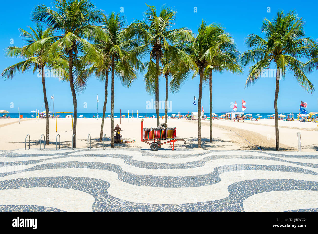 Luminoso vista panoramica della spiaggia di Copacabana con palme accanto alla mitica boardwalk a Rio de Janeiro in Brasile Foto Stock