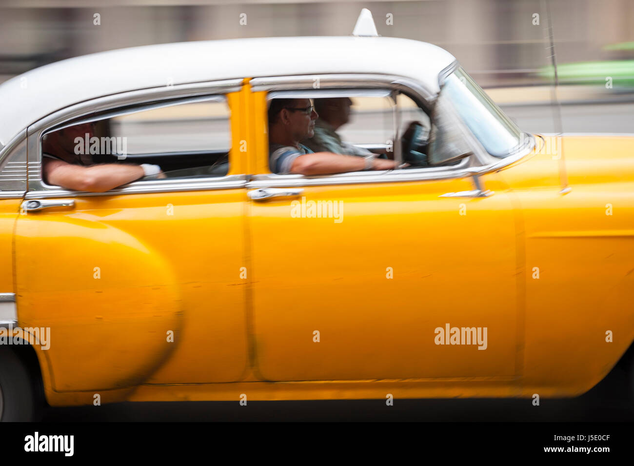 L'Avana - Giugno, 2011: Colore giallo brillante vintage americano auto lavorando come condividere un taxi impiega i passeggeri lungo il lungomare Malecon street. Foto Stock