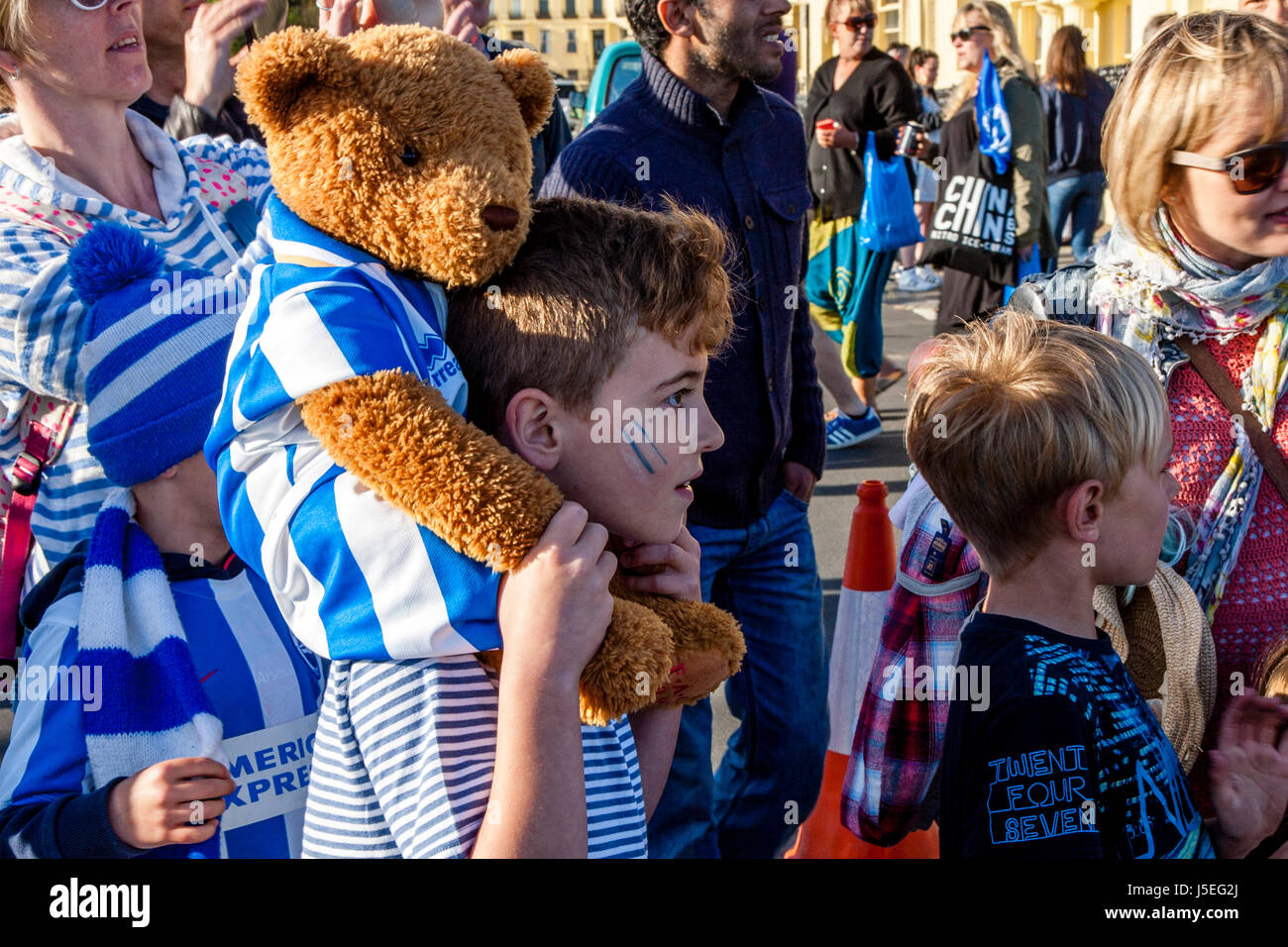 I giovani di Brighton e Hove Albion tifosi guardare l'autobus squadra passando lungo il mare durante il Club di promozione Parade, Brighton, Sussex, Regno Unito Foto Stock