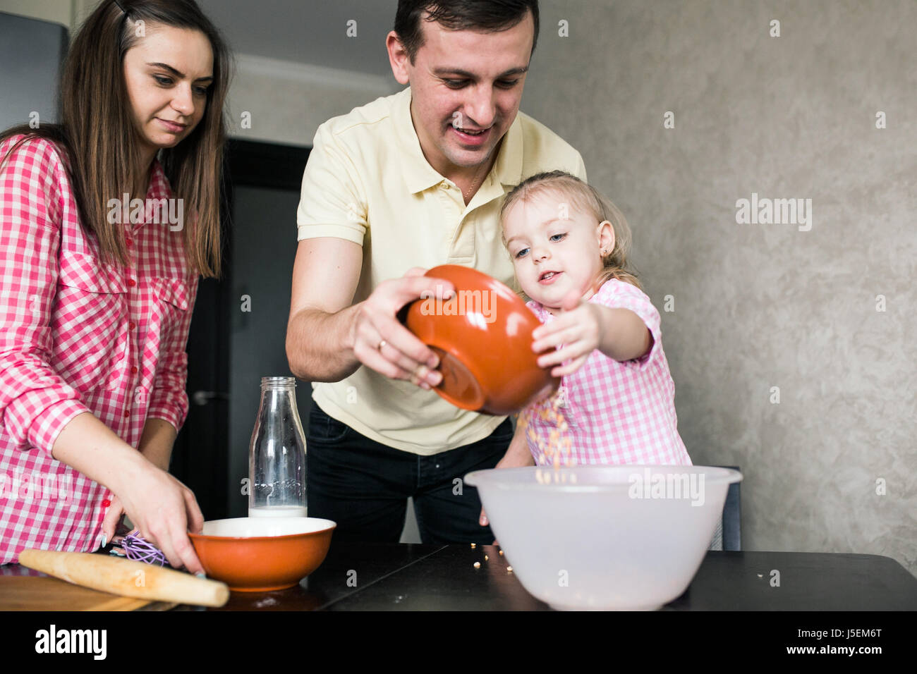 Papà, mamma e figlia insieme in cucina Foto Stock