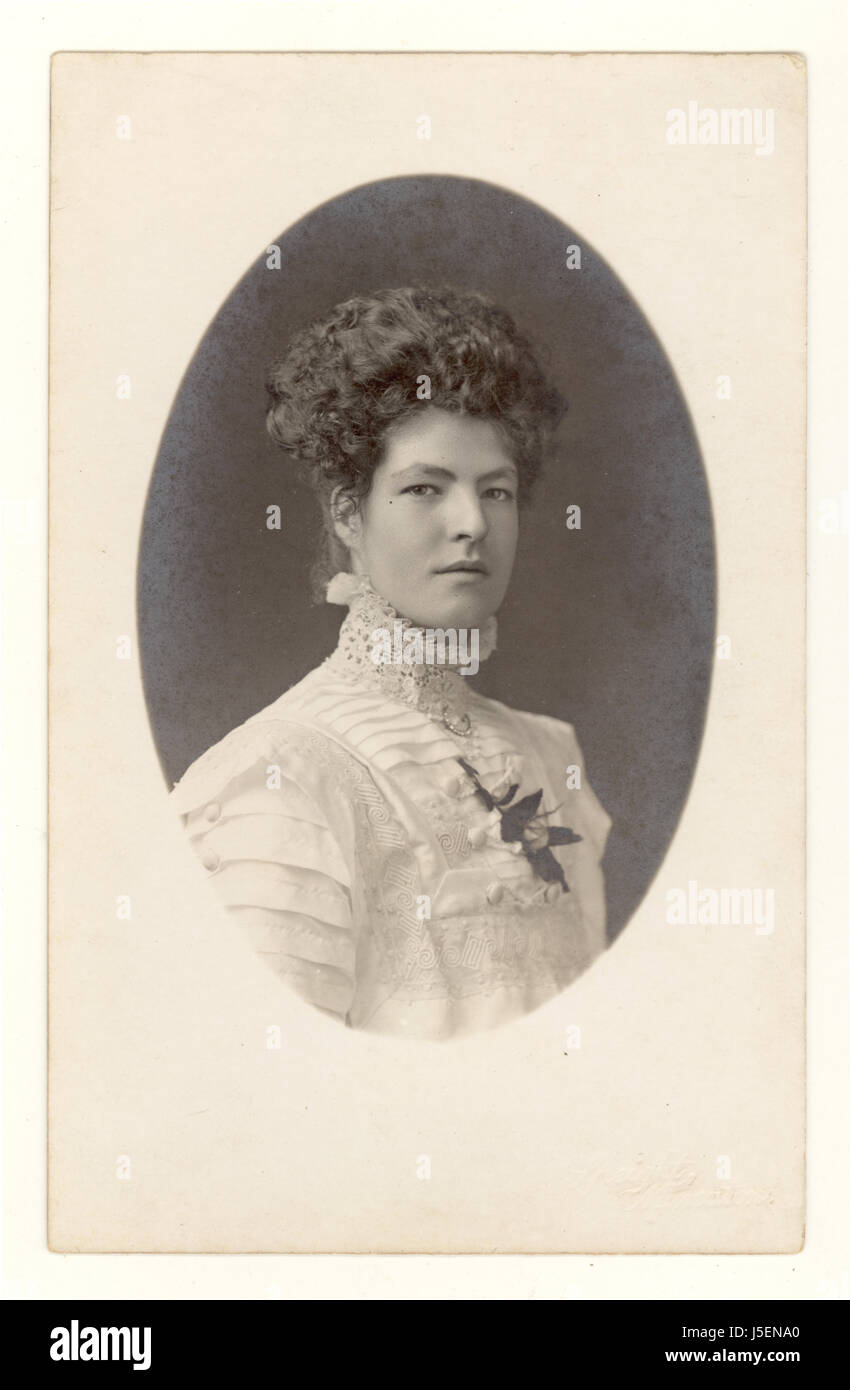 Cartolina di elegante classica elegante e alla moda signora Edwardian attraente, guardando direttamente la macchina fotografica, forte voluto, sicuro, indossando una blouse ad alto collo circa 1905,1906 U.K. Foto Stock