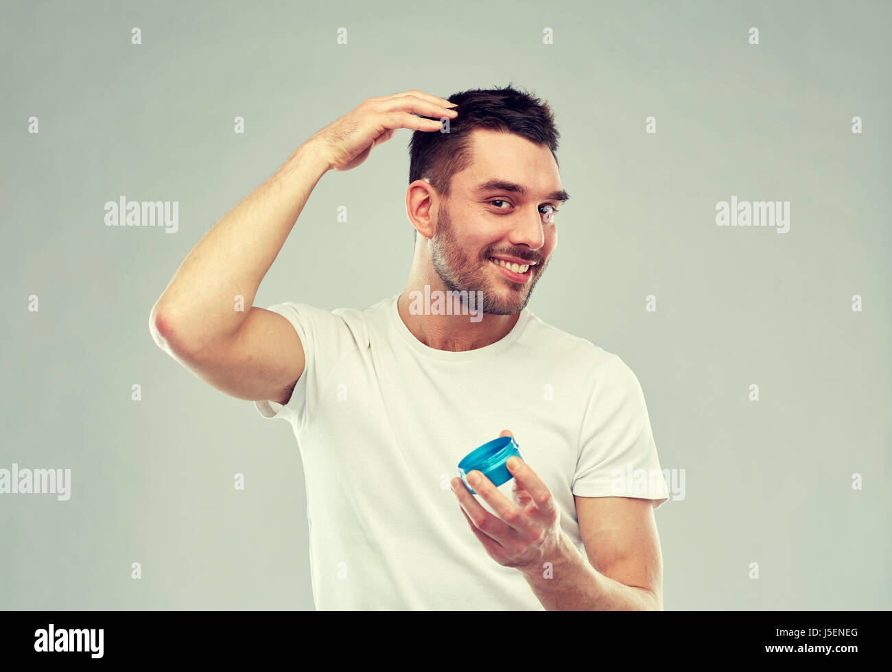 Felice giovane uomo styling i capelli con la cera o gel Foto Stock