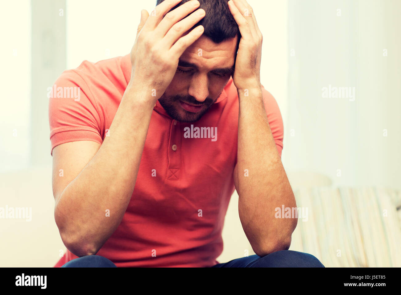 Uomo infelice che soffrono di mal di testa a casa Foto Stock