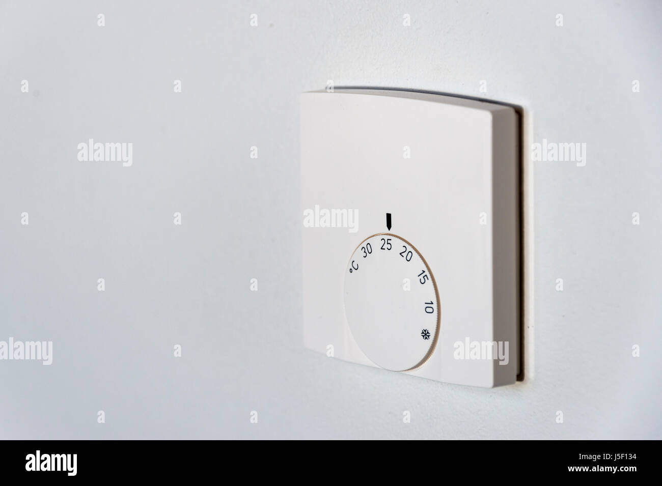 Comando termostatico su un muro bianco Foto Stock