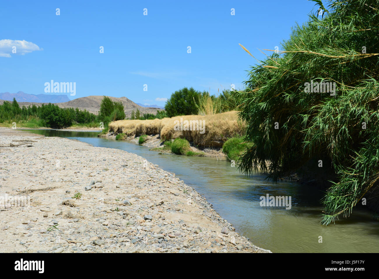 Acqua bassa nel Rio Grande lascia solo un canale stretto in alveo come emerge dalla Santa Elena Canyon al parco nazionale di Big Bend Foto Stock