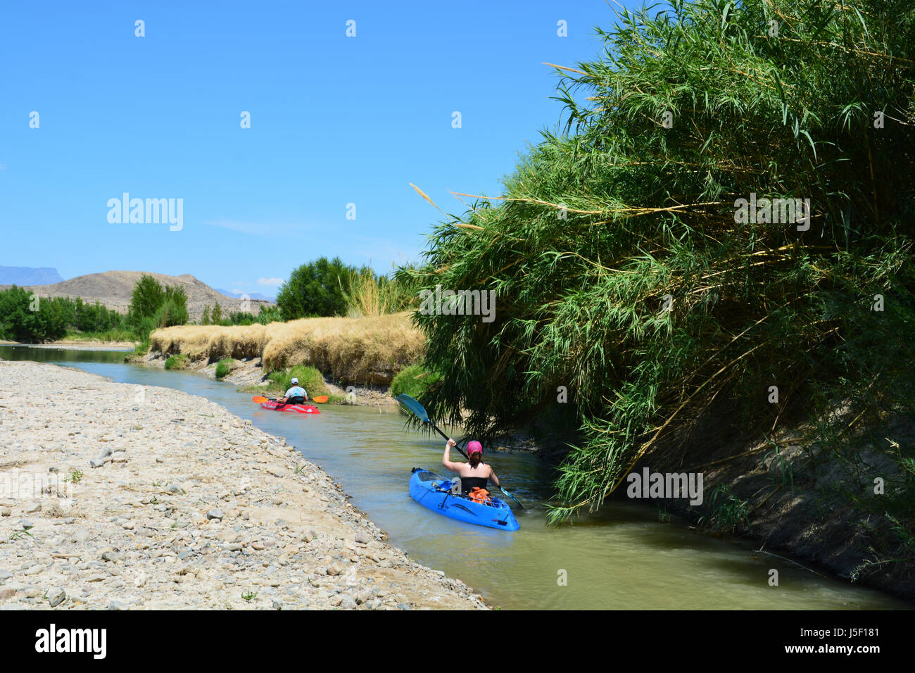 Kayak navigare un canale stretto nelle acque basse del Rio Grande come esce Santa Elena Canyon al parco nazionale di Big Bend Foto Stock