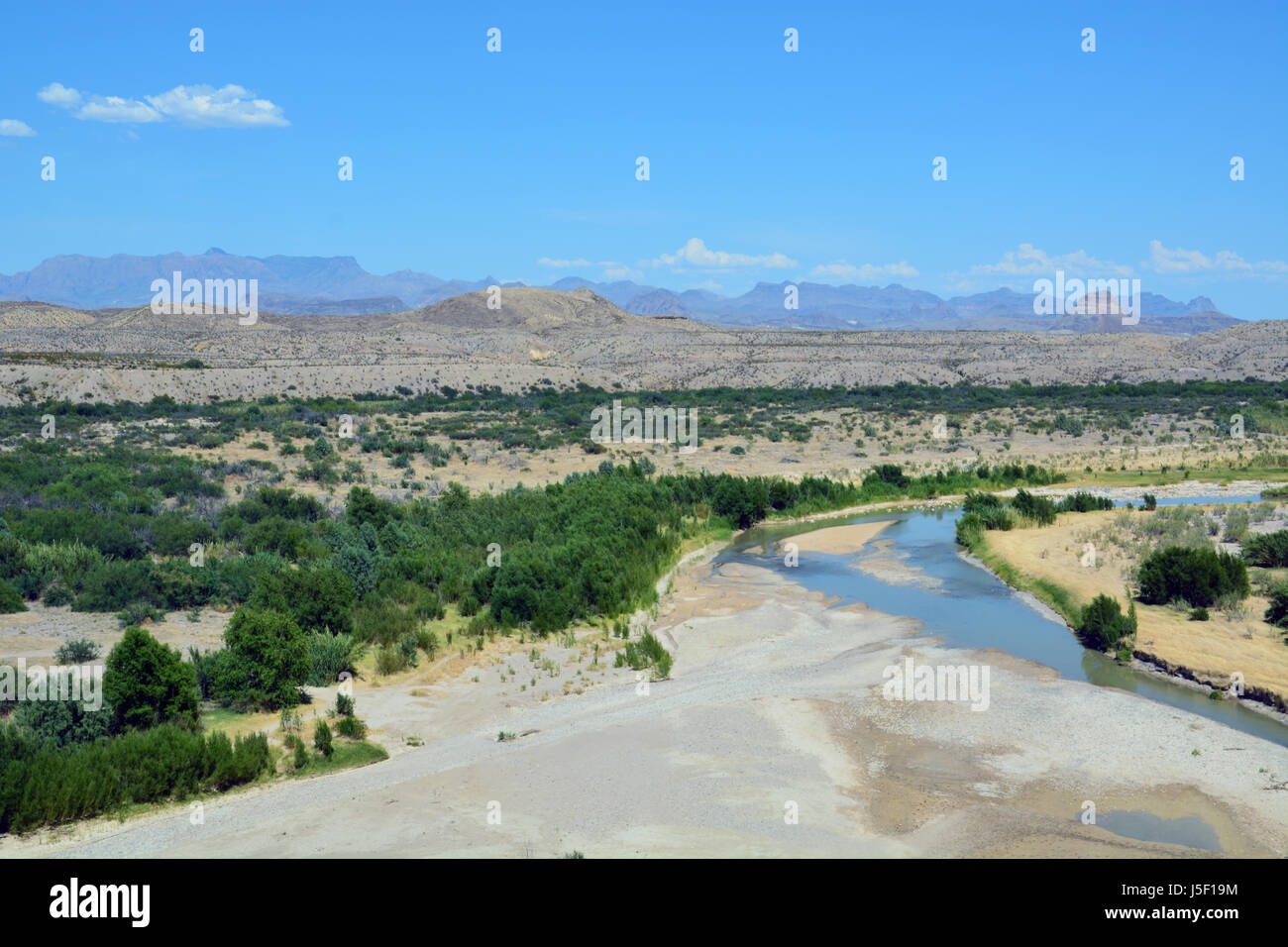Acqua bassa nel Rio Grande lascia solo un canale stretto in alveo come emerge dalla Santa Elena Canyon al parco nazionale di Big Bend Foto Stock