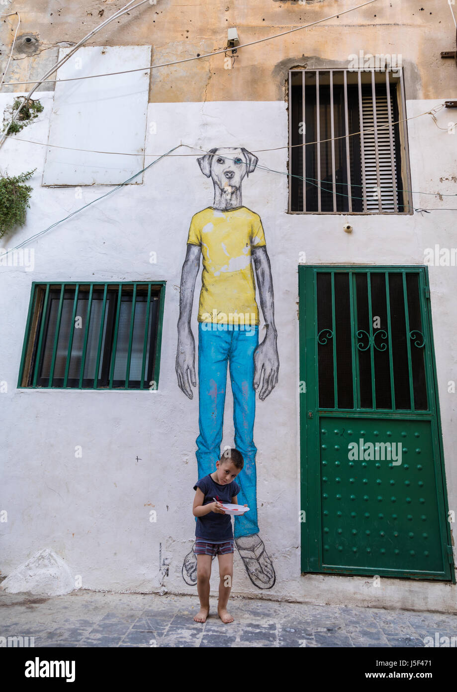 Capretto libanese in piedi di fronte a un enorme cane dipinto nella Street, South Governatorato, pneumatico, Libano Foto Stock