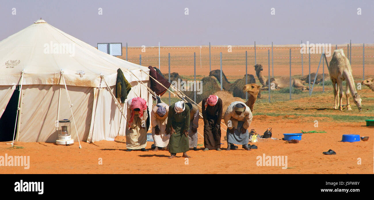 La religione convinzione vasto deserto asia pregare cammelli vendita est turbante islam arabia Foto Stock