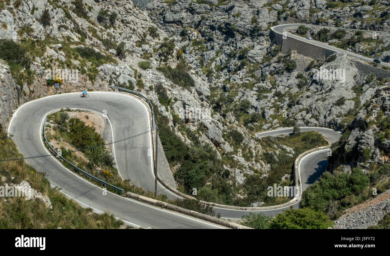 Ciclista femmina persona sulla famosa strada tortuosa verso il basso per il villaggio costiero di Sa Calobra, Mallorca, Maiorca, isole Baleari, Spagna Foto Stock