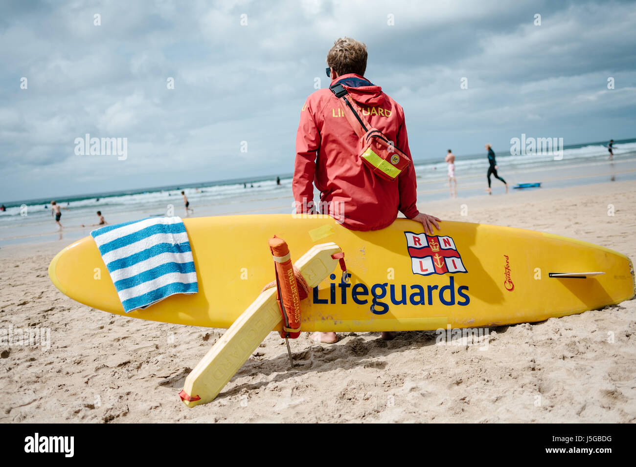 Australian RNLI Lifeguard mantenendo una guardia spiaggia Gwithian in Cornovaglia. Foto Stock