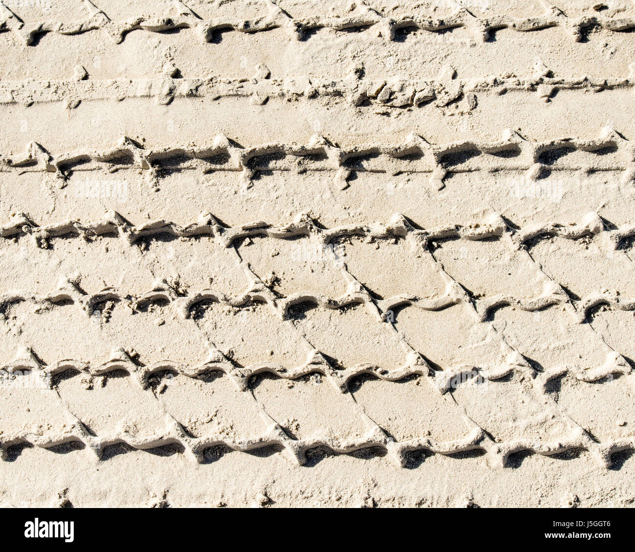 In un pneumatico di un veicolo le vie nella sabbia. La guida è consentita sulla spiaggia di Port Aransas, Texas USA, lasciando tracce della giornata di attività. Foto Stock