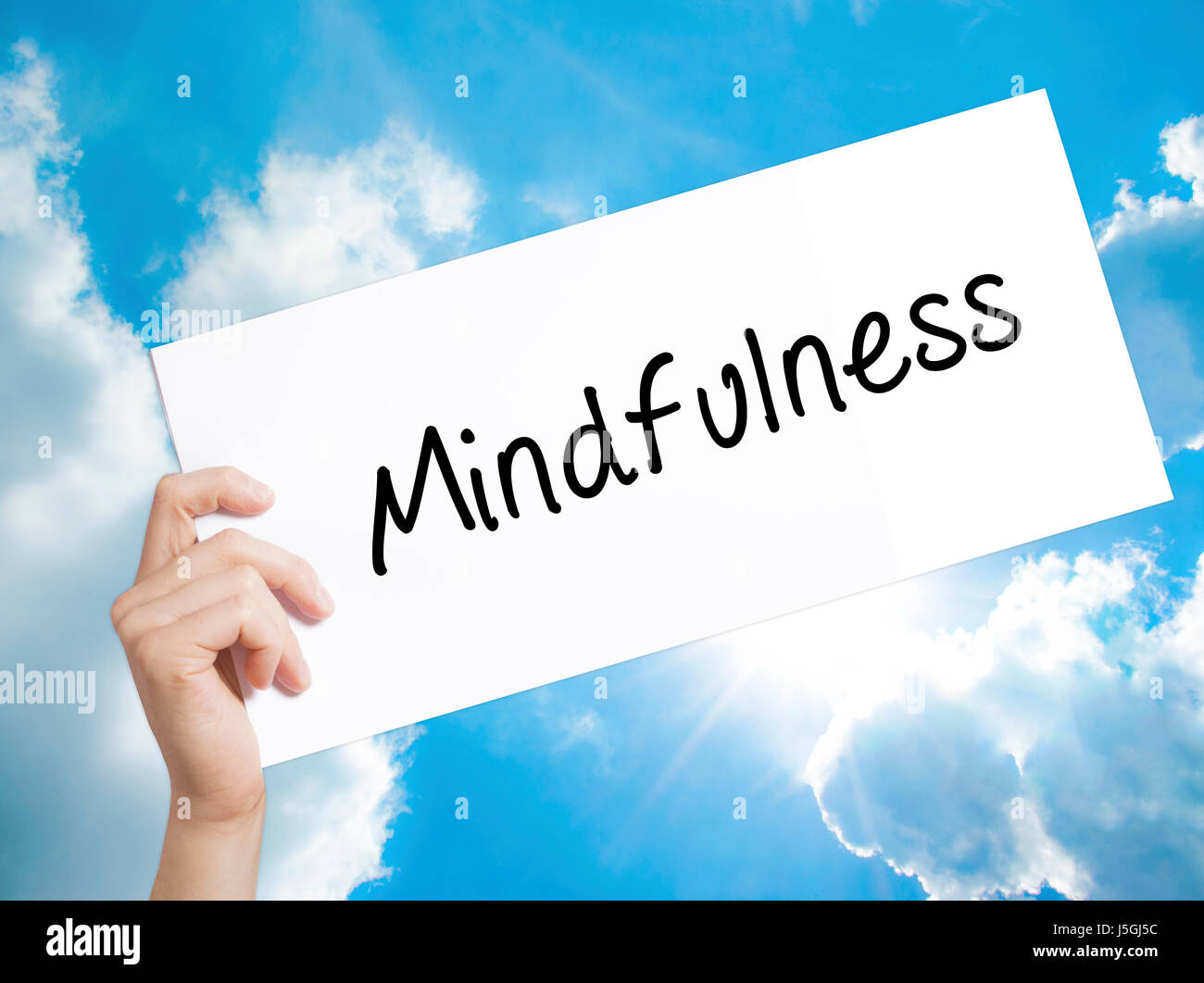 Mindfulness segno su carta bianca. Man mano che tiene la carta con testo. Isolato su sfondo cielo. Il concetto di business. Stock Photo Foto Stock