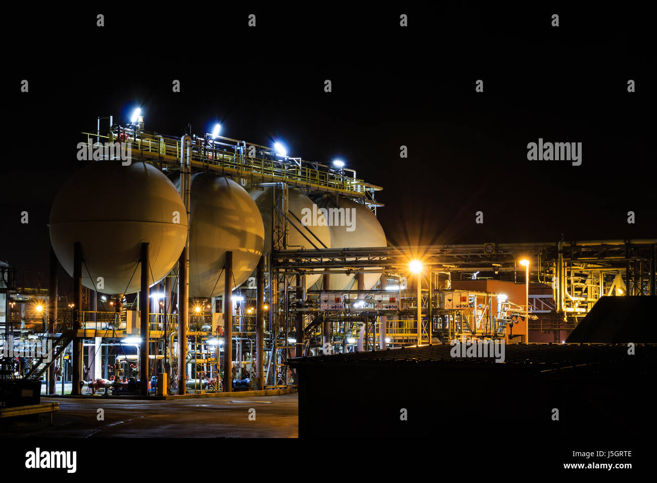 Acido cloridrico serbatoi della raffineria petrolchimica di notte. Tessenderlo, Fiandre, in Belgio, Europa Foto Stock