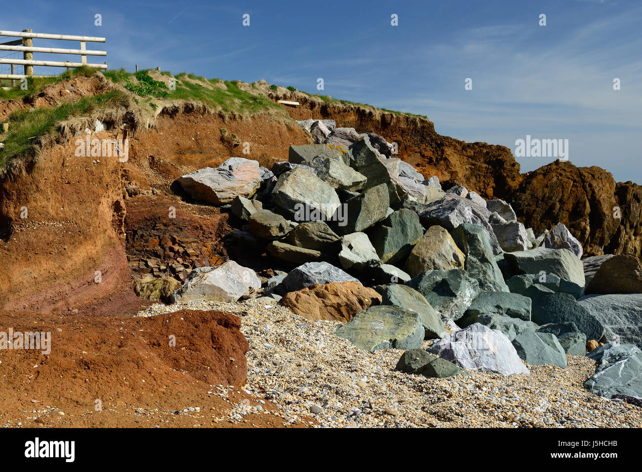 Erosione costiera rinforzati da armature di roccia. Foto Stock