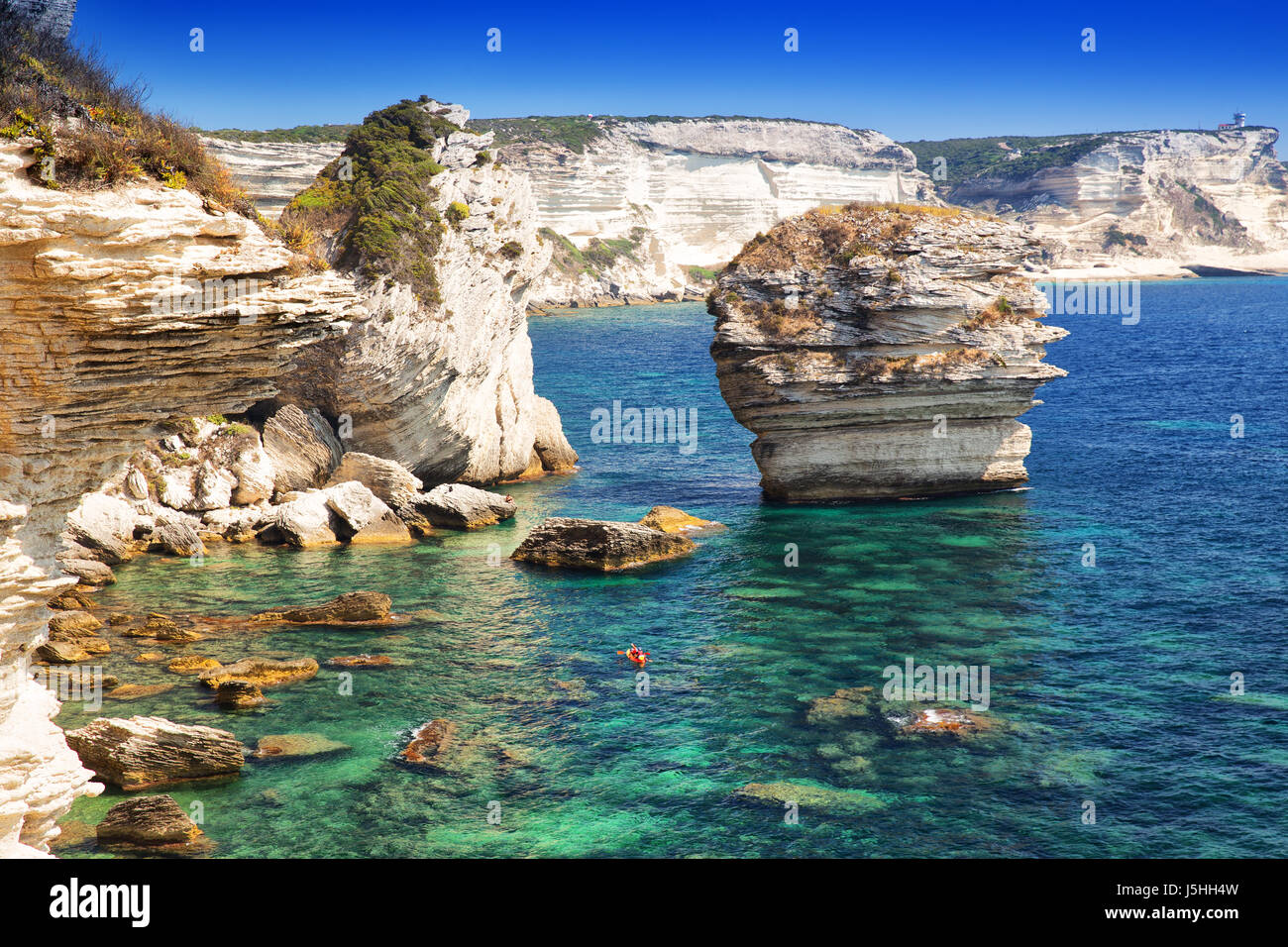 Coppia giovane kayak vicino a Bonifacio cittadina sulla splendida roccia bianca scogliera con Baia Mare, Corsica, Francia, Europa. Foto Stock