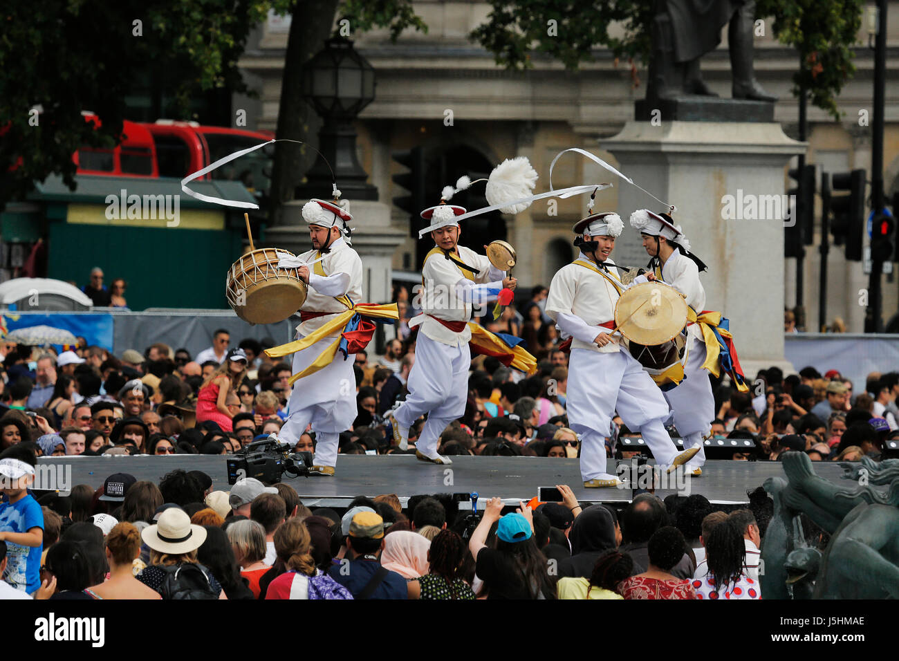 London, Regno Unito - 9 Agosto 2015: di etnia coreana ballerini eseguono, Nongak, gli agricoltori' danza, in coreano la festa a Trafalgar Square, spettatori presenti. Foto Stock