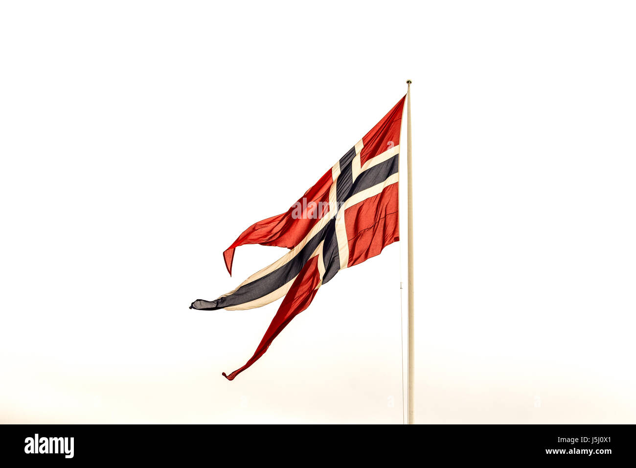 Bandiera norvegese su un pennone bianco con cielo bianco in background Foto Stock