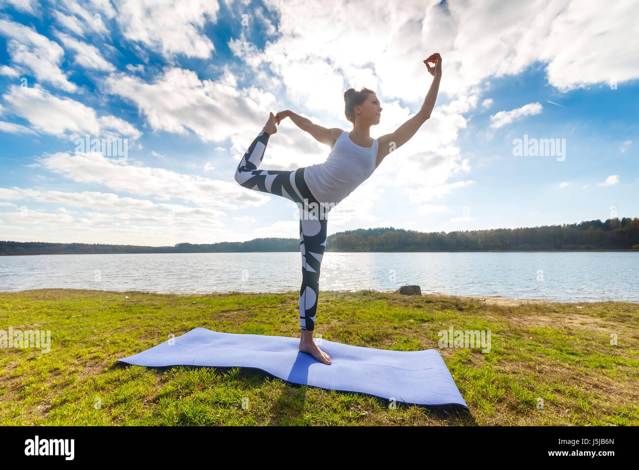 Giovane donna fare yoga vicino al lago all'aperto, la meditazione. Sport e  fitness di esercitare nella natura. Tramonto d'autunno Foto stock - Alamy