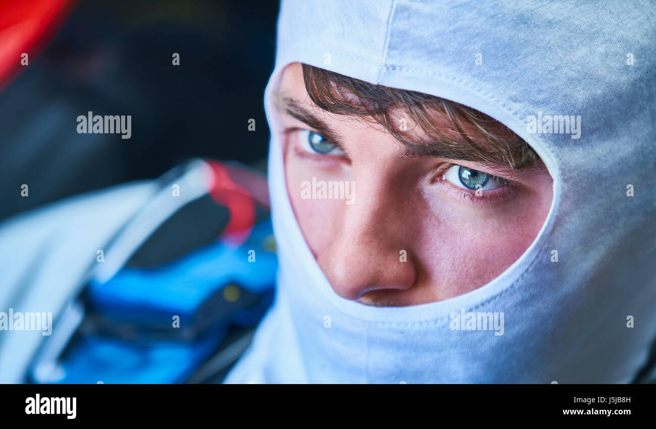 Close up grave race driver di automobile di indossare la maschera protettiva Foto Stock