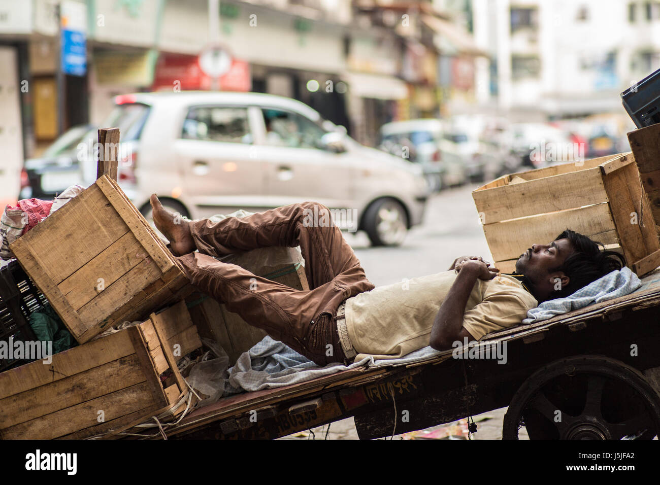 Un uomo indiano prendendo un pisolino durante le ore calde. Foto Stock