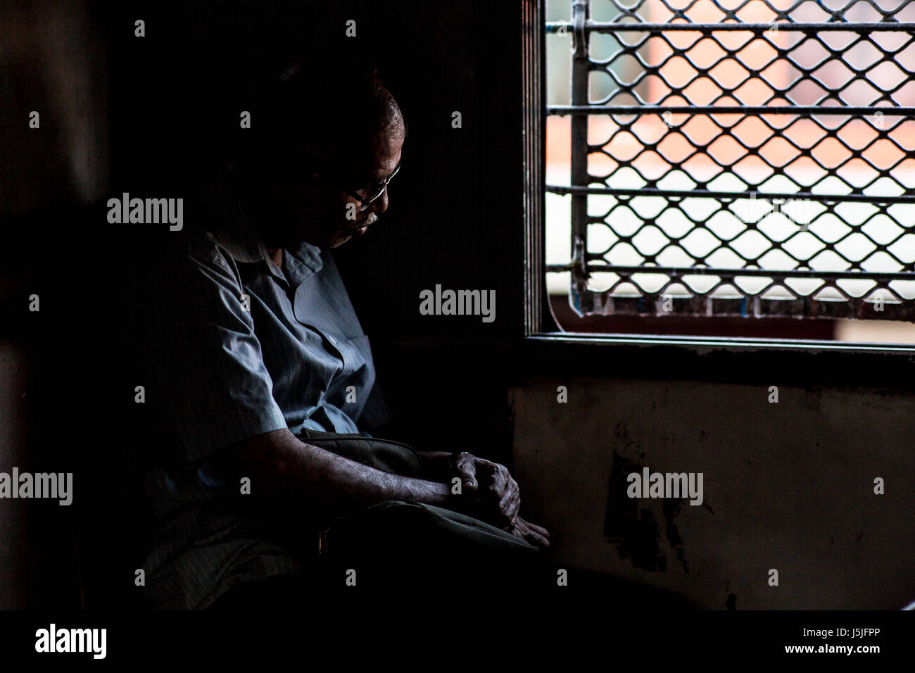 Un uomo che dorme sul treno locale a Mumbai Foto Stock