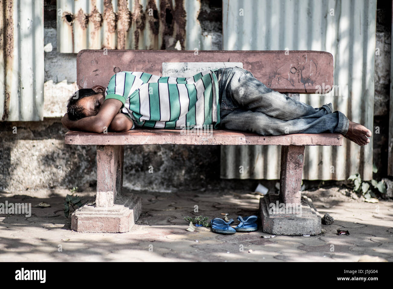 Uomo di dormire su un banco di lavoro Foto Stock