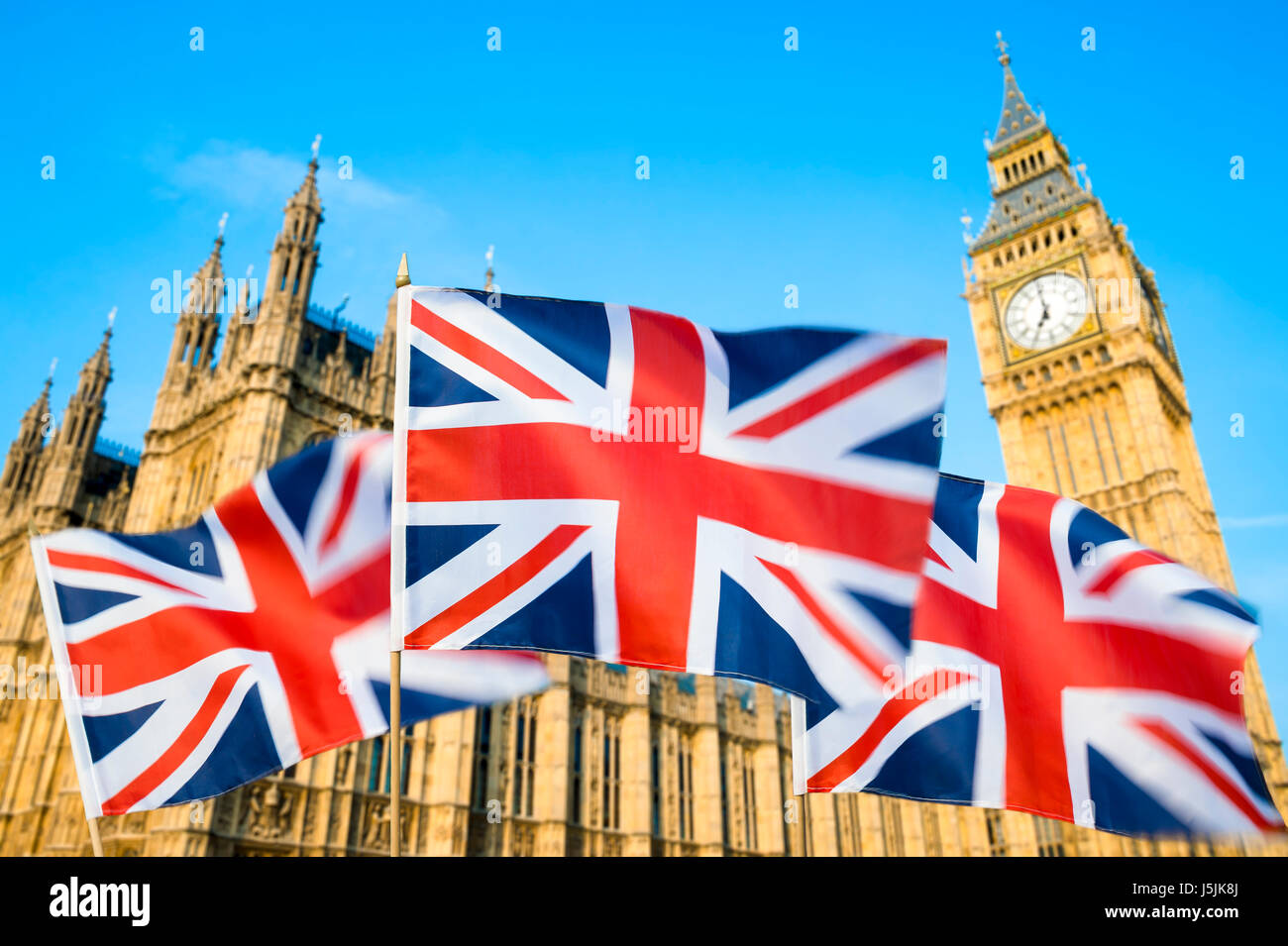 Grande britannica Union Jack flag sflying in motion blur nella parte anteriore del Big Ben e le Camere del Parlamento presso il Palazzo di Westminster, Londra, Regno Unito Foto Stock