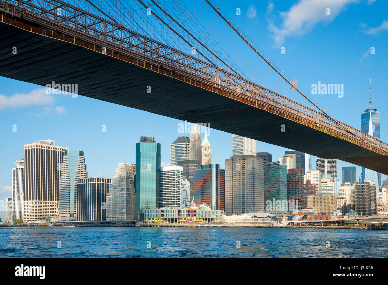 Luminoso vista panoramica del Ponte di Brooklyn con la parte inferiore della skyline di Manhattan da East River Foto Stock