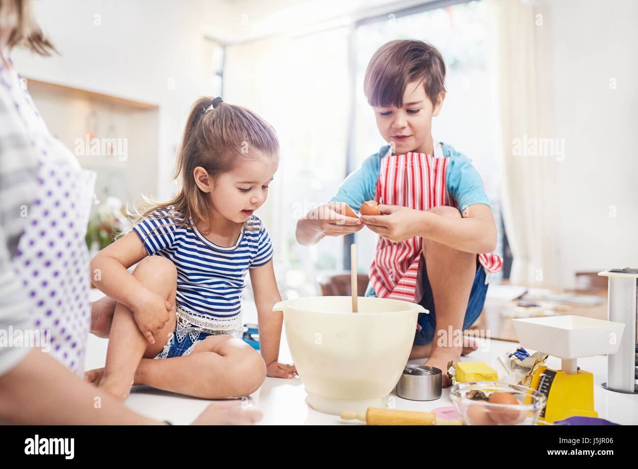 Un ragazzo e una ragazza, fratello e sorella di cottura sul banco di cucina Foto Stock