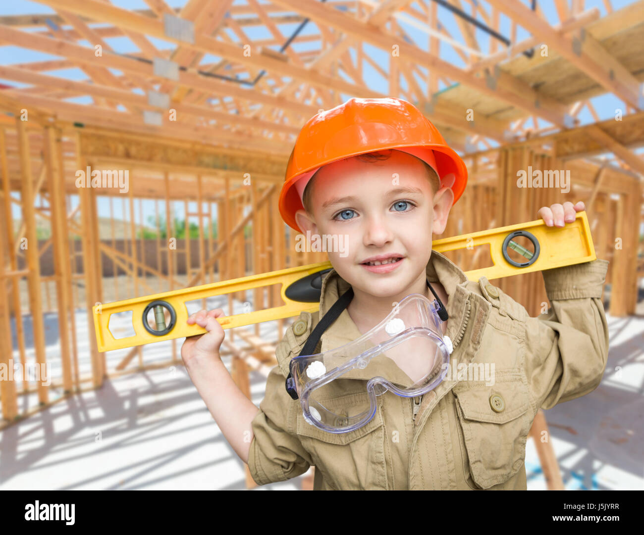 Ragazzo giovane imprenditore con il livello sul sito all'interno di nuova costruzione in casa Framing. Foto Stock