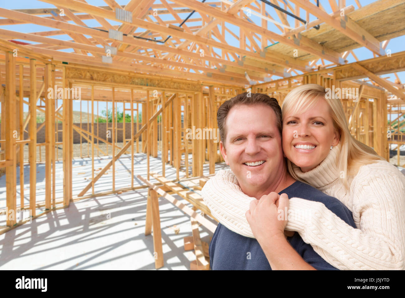 Felice eccitato giovane sul sito interno della loro nuova casa Costruzione Framing. Foto Stock