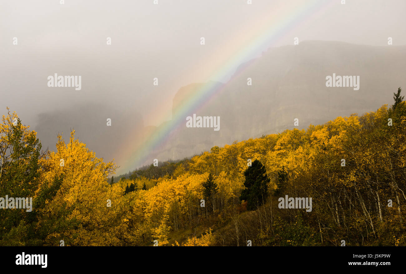 Una tempesta passa sopra l'ingresso est del Parco Nazionale di Glacier creando un arcobaleno Foto Stock