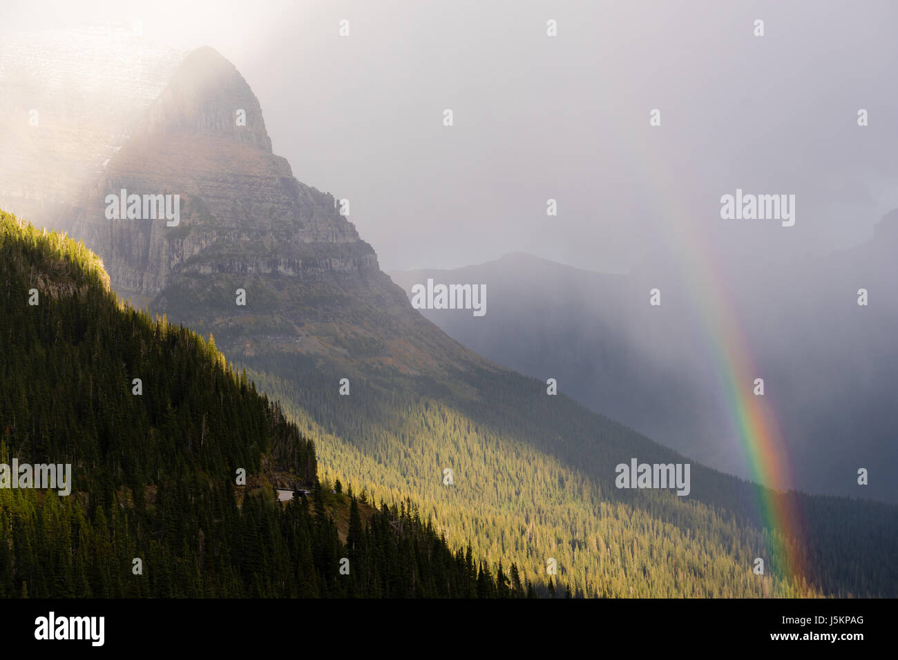 Una tempesta passa sopra il centro del Parco Nazionale di Glacier creando un arcobaleno Foto Stock