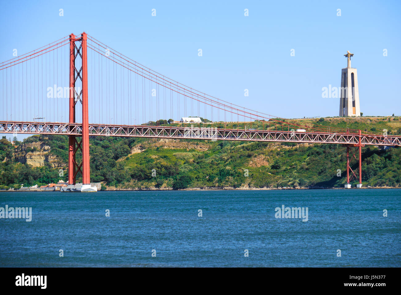 Xxv Aprile sospensione ponte ponte sul fiume Tago con Gesù Cristo Re statua sullo sfondo a Lisbona, Portogallo Foto Stock