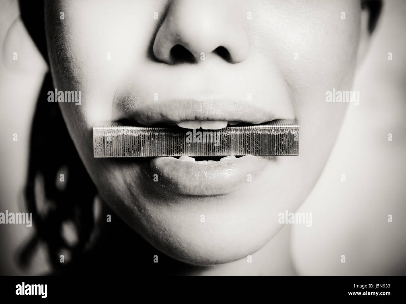 Donna faccia particolare in acciaio con fiocco in bocca e dei denti, in bianco e nero Foto Stock