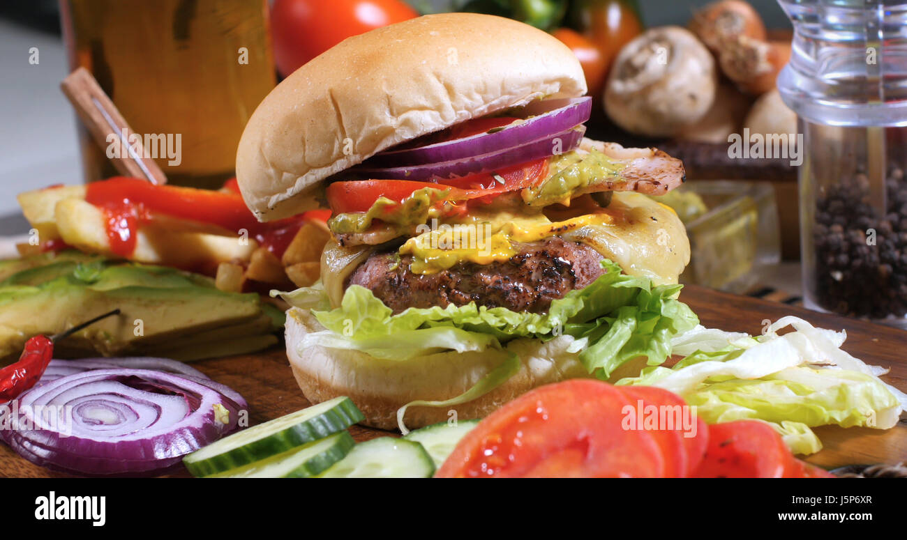Vista di una deliziosa cheeseburger con baco e guacamole Foto Stock