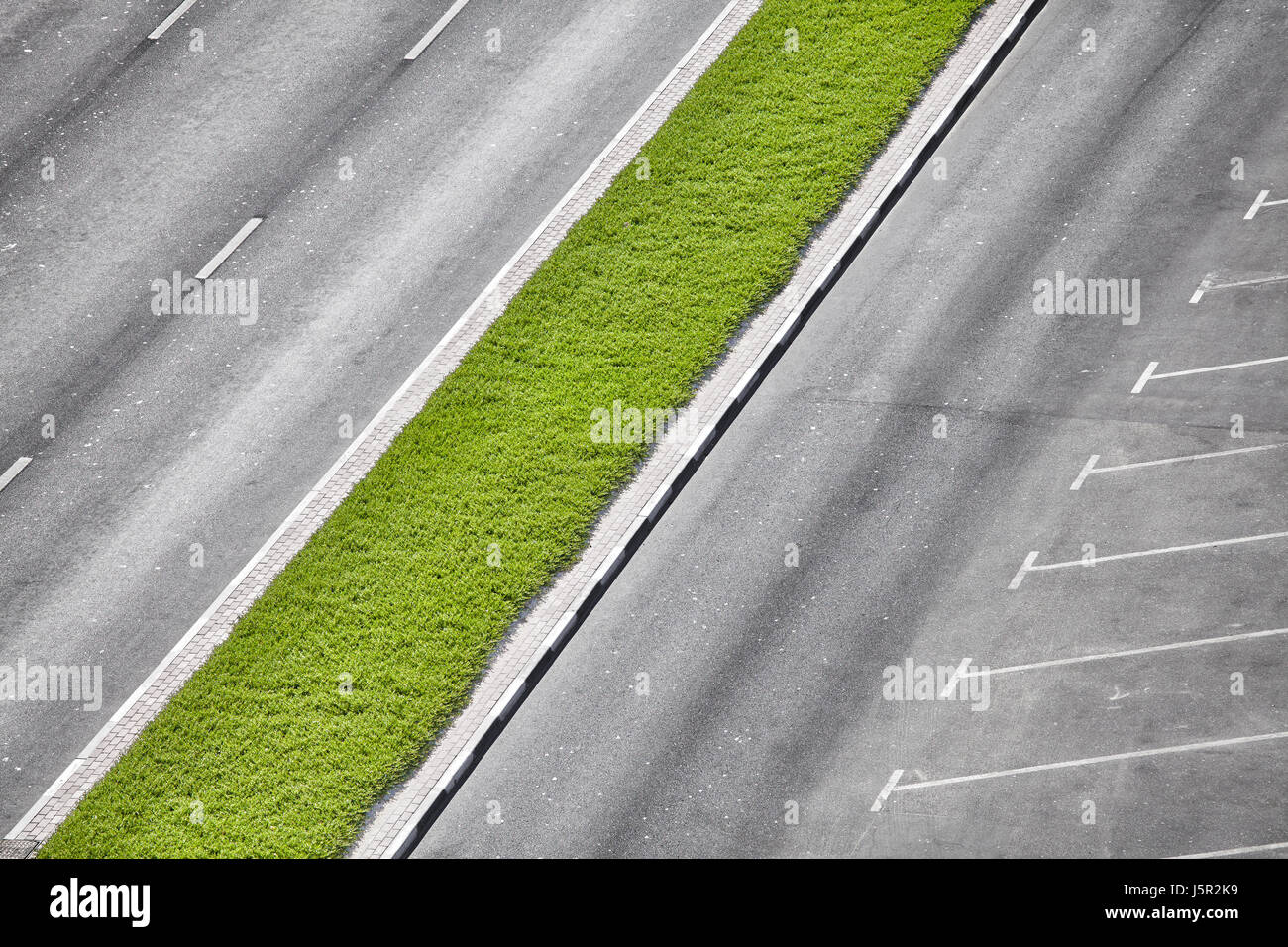 Fotografia aerea di una strada vuota, verde centrale di prenotazione e di un parcheggio. Foto Stock