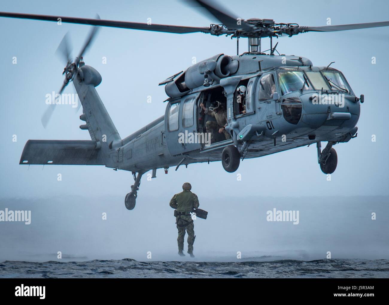 Un U.S. Navy SEAL commando salta fuori di un USN MH-60 Seahawk elicottero durante una formazione helocasting missione Maggio 8, 2017 al largo di Guam. (Foto di MCS1 Torrey W. Lee /US Navy via Planetpix) Foto Stock
