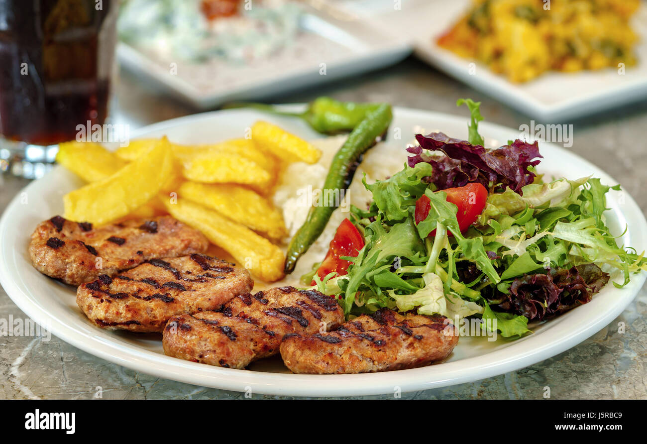 Polpetta, patatine fritte e riso con verdura a foglia. Foto Stock