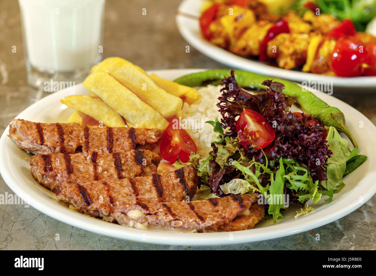 Polpetta, patatine fritte e riso con verdura a foglia. Foto Stock