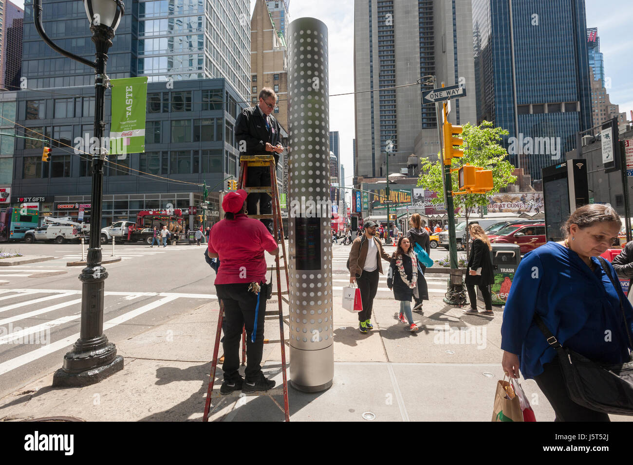 Lavoratori regolare uno dei nuovi chioschi wayfinding che stare in corrispondenza di entrambe le estremità di una fila di ristoranti di New York, West 46th Street tra l ottavo e il nono viali, martedì 16 maggio, 2017. Almeno quattro anni nel rendere i chioschi illuminato mostra i nomi di molti ristoranti che popolano la strada. L'inaugurazione è appena in tempo per il gusto di Times Square manifestazione che si svolge sulla strada a giugno 5. (© Richard B. Levine) Foto Stock