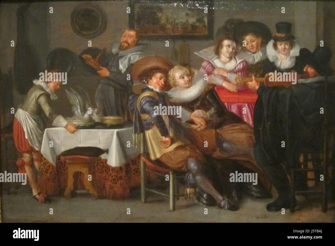 "Interior with Merry Company" è un dipinto del XIX secolo che mostra una scena vivace all'interno di una stanza con un gruppo di persone che si impegnano in interazione sociale, catturando lo spirito della sua epoca. Foto Stock