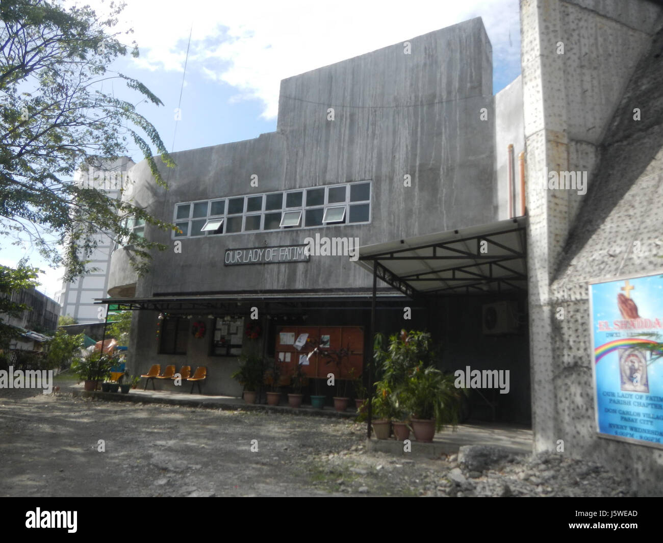 Questa immagine raffigura Barangay Don Carlos Village Street nella zona di Malibay di Pasay City, Metro Manila. Mostra una tipica scena urbana nelle Filippine, con edifici residenziali e commerciali intervallati lungo la strada. La Parrocchia di Fatima è anche un punto di riferimento fondamentale, che rappresenta la vita religiosa e culturale della comunità. Foto Stock