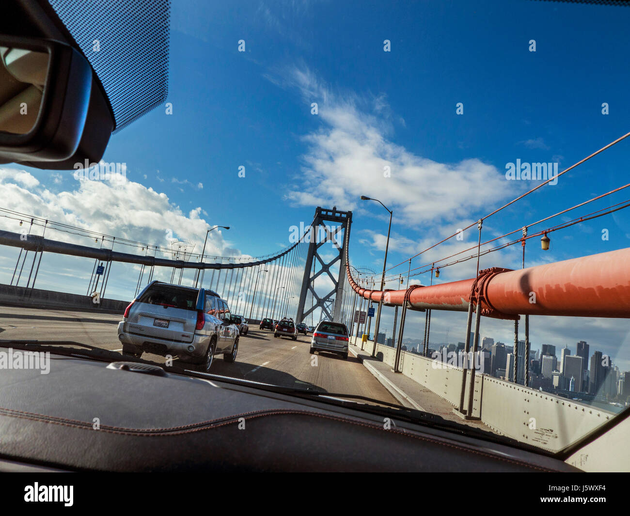 Ponte della Baia di SAN FRANCISCO POV vista dalla macchina attraversando il Bay Bridge con la città di San Francisco e il centro finanziario edifici tra cui il Ferry Building su Embarcadero, San Francisco California USA Foto Stock