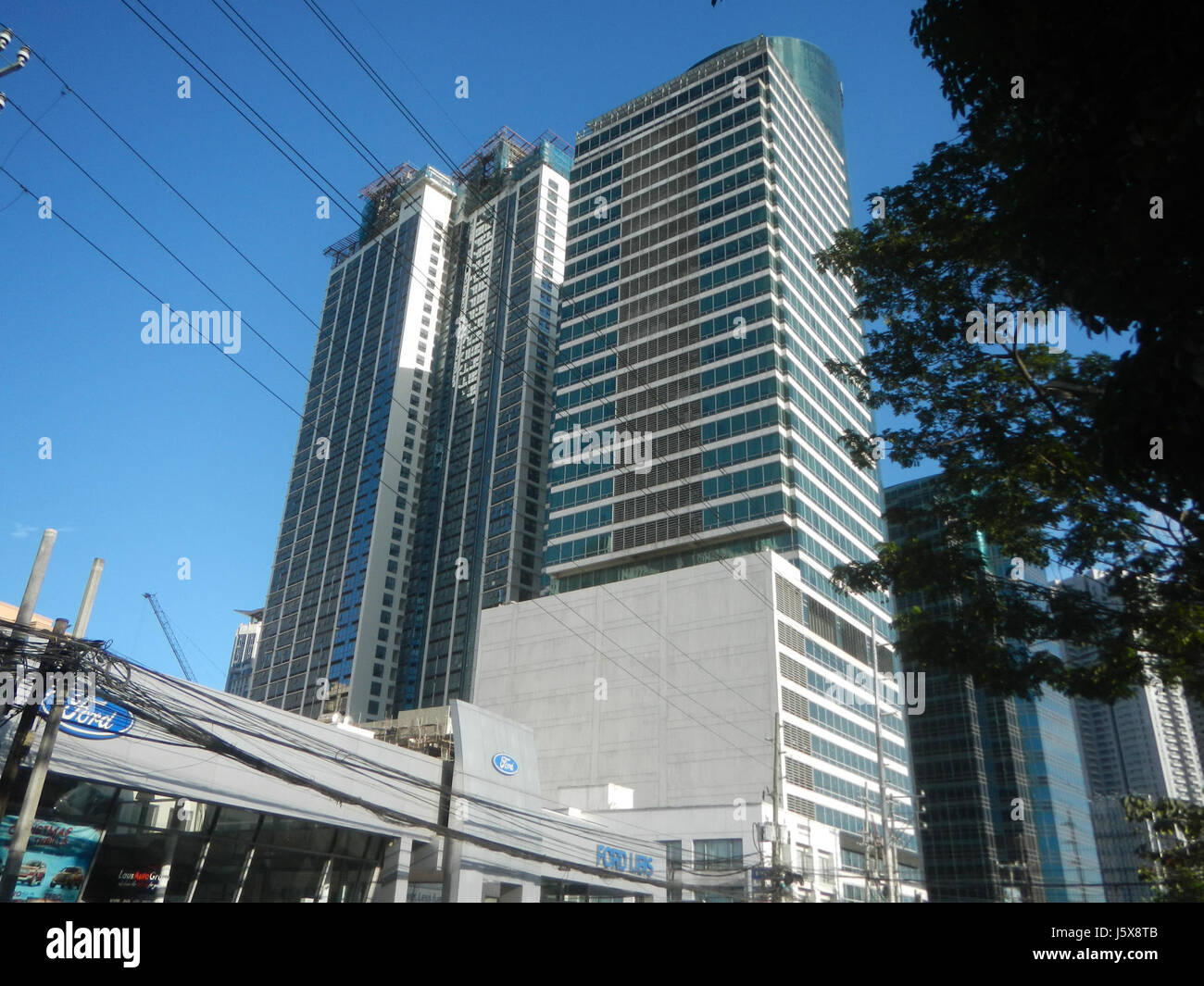 Questo titolo si riferisce alle località urbane di Quezon City, Filippine, evidenziando aree come Bagumbayan, Libis e Eastwood City. Questi luoghi sono caratterizzati da edifici e spazi commerciali di rilievo, contribuendo al paesaggio urbano e alle infrastrutture della città. Foto Stock