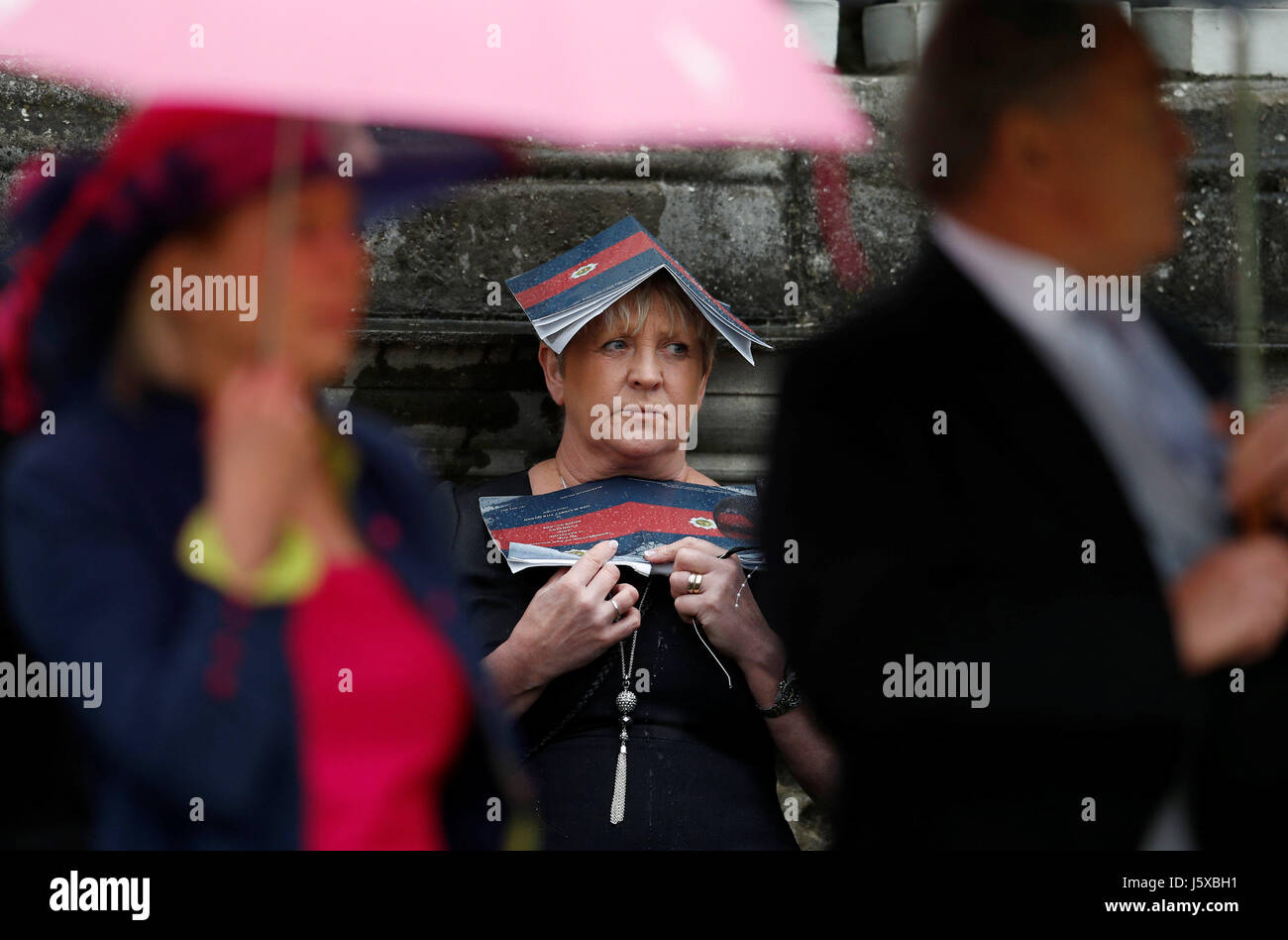 Una valutazione ripari dalla pioggia come la Regina Elisabetta II assiste una cerimonia per presentare i nuovi colori per il primo battaglione e F Azienda guardie scozzesi a Buckingham Palace a Londra. Foto Stock