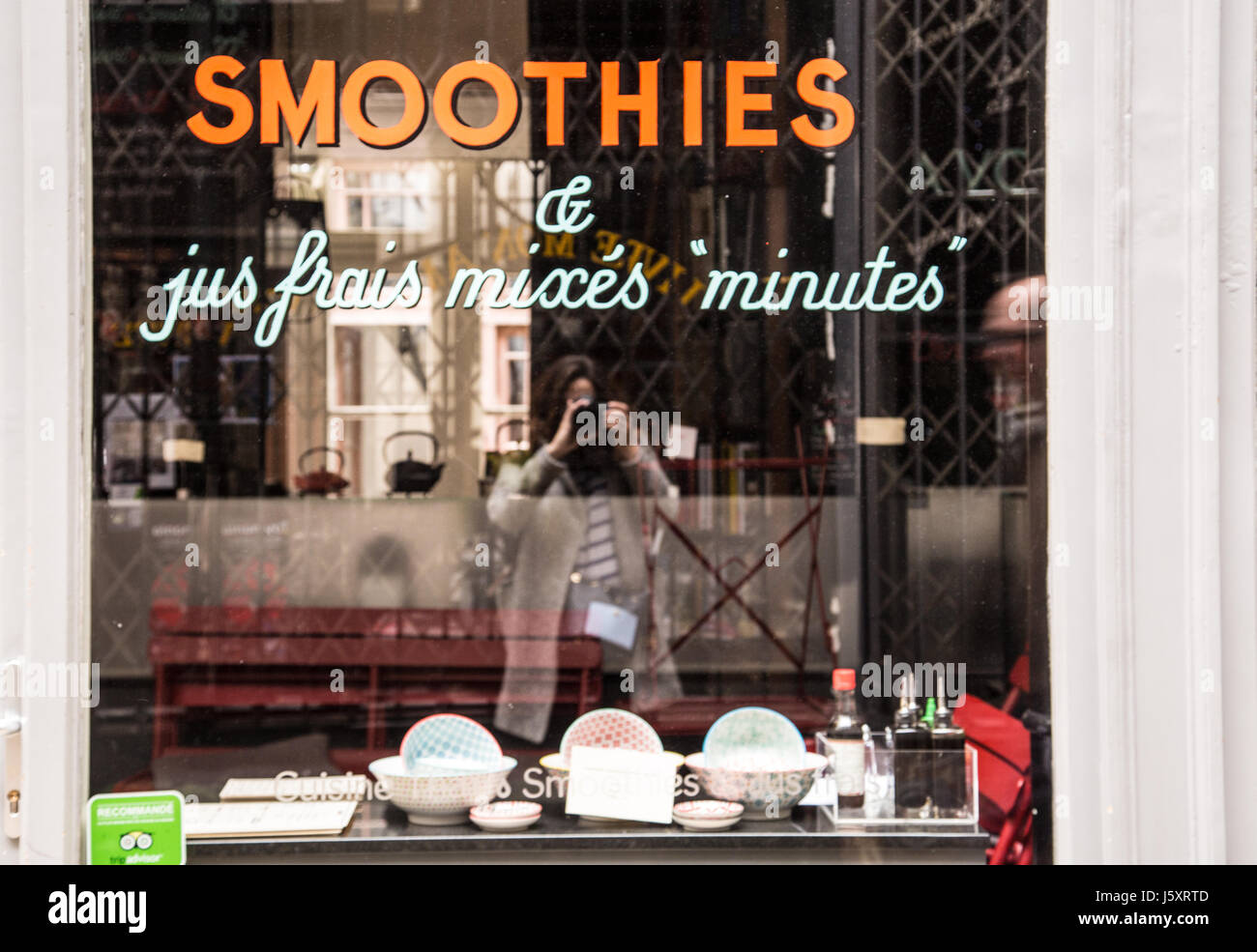 Fotografo riflesso in una vetrina di un negozio di frullati in Parigi, Francia. Foto Stock